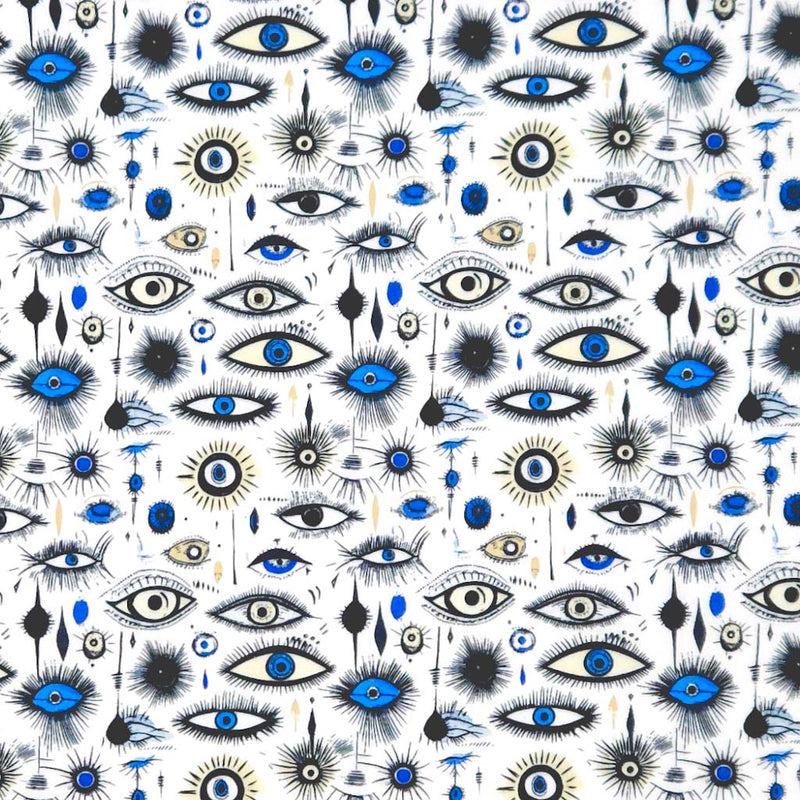Pattern of stylized eyes with blue irises on a white polycotton fabric