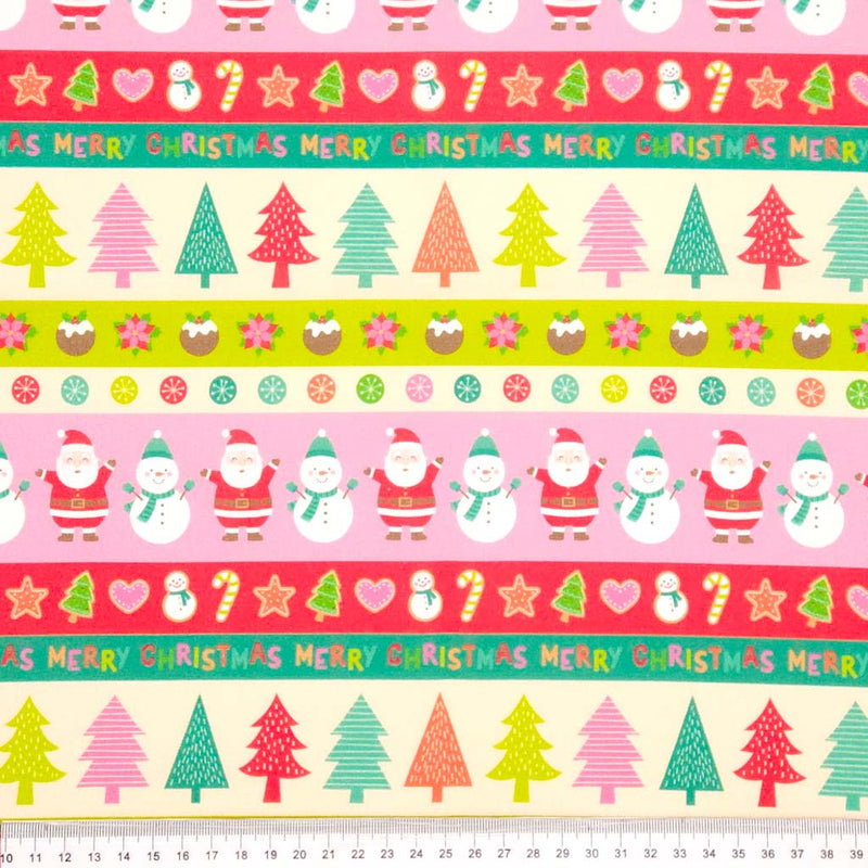 Colourful Christmas-themed fabric with Santa Claus, trees, and candy canes on a pink cotton fabric.