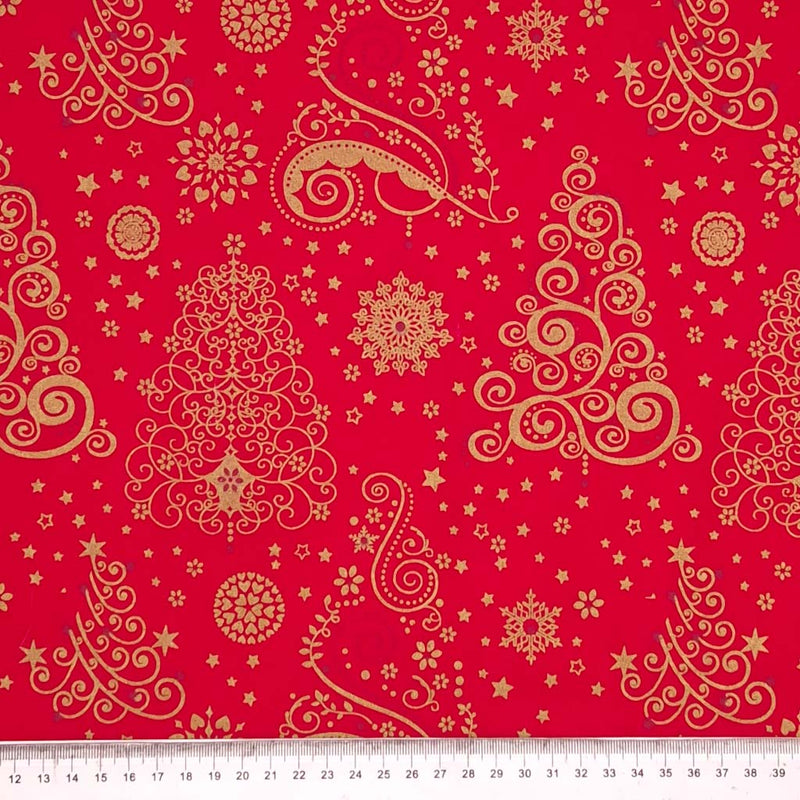 Large gold christmas trees printed on a red cotton fabric with a cm ruler