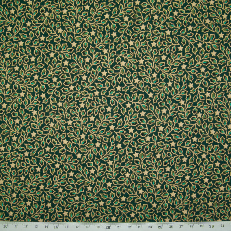 Mini holly leaves in gold and green are printed on a christmas cotton fabric