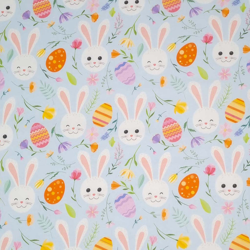 Easter fabric with bunny faces and easter eggs on a pastel blue cotton fabric