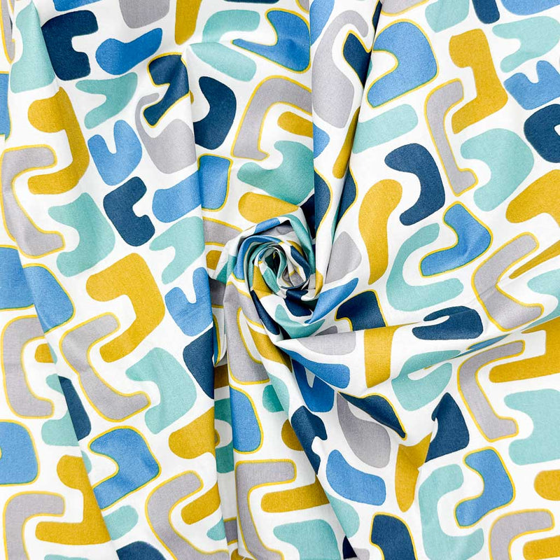 Abstract shapes of blue and yellow on a contrasting, bold white background printed on an 100% cotton fabric