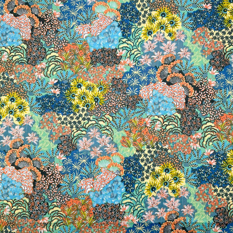 A bright fabric with multicoloured flower displays printed on a dark dressmaking cotton fabric