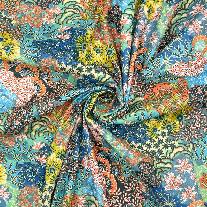 A bright fabric with multicoloured flower displays printed on a dark dressmaking cotton fabric