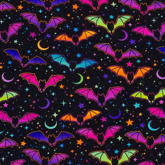 Neon pink and blue flying bats and stars are printed on a black cotton jersey fabric