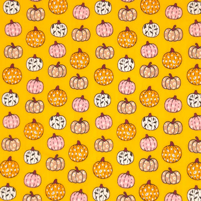 Ditsy decorated pumpkins are printed on an orange polycotton fabric for halloween