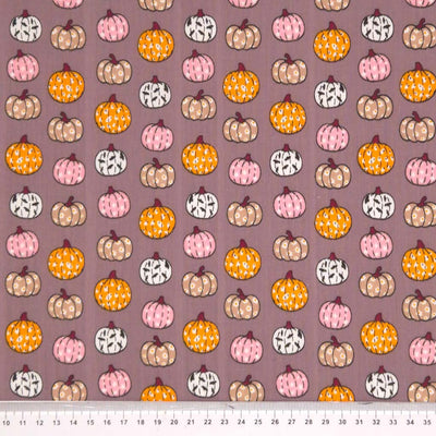 Ditsy decorated pumpkins printed on a grey polycotton fabric with a cm ruler