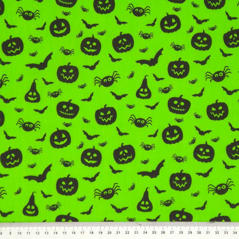 Halloween creatures printed on a neon green polycotton fabric with a cm ruler