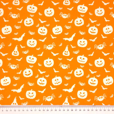 Halloween creatures printed on an orange polycotton fabric with a cm ruler