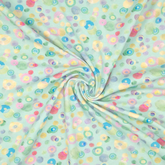 Pastel coloured spots printed on an aqua cotton jersey fabric