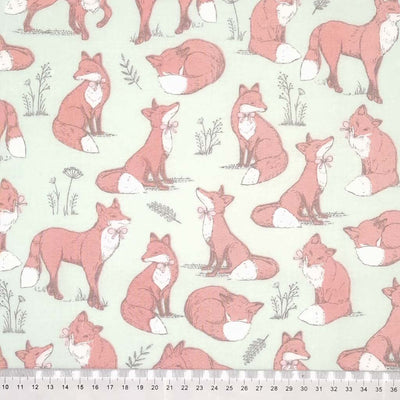 Brown foxes printed on a duck egg cotton fabric with a cm ruler