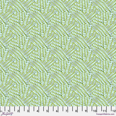 Patterned fabric with a grid-like design on a green cotton quilting fabric, featuring a ruler at the bottom.