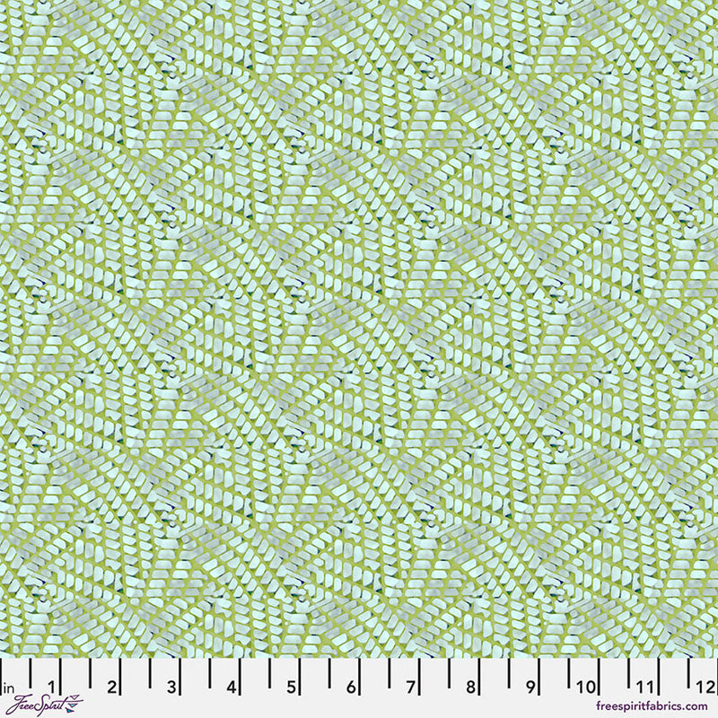 Patterned fabric with a grid-like design on a green cotton quilting fabric, featuring a ruler at the bottom.