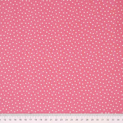 Tiny stars and spots printed on a pink cotton poplin fabric by Rose & Hubble with a cm ruler