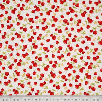Ditsy red strawberries printed on an ivory cotton poplin fabric with a cm ruler