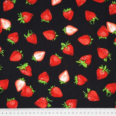 Red strawberries printed on a black cotton poplin fabric with a cm ruler