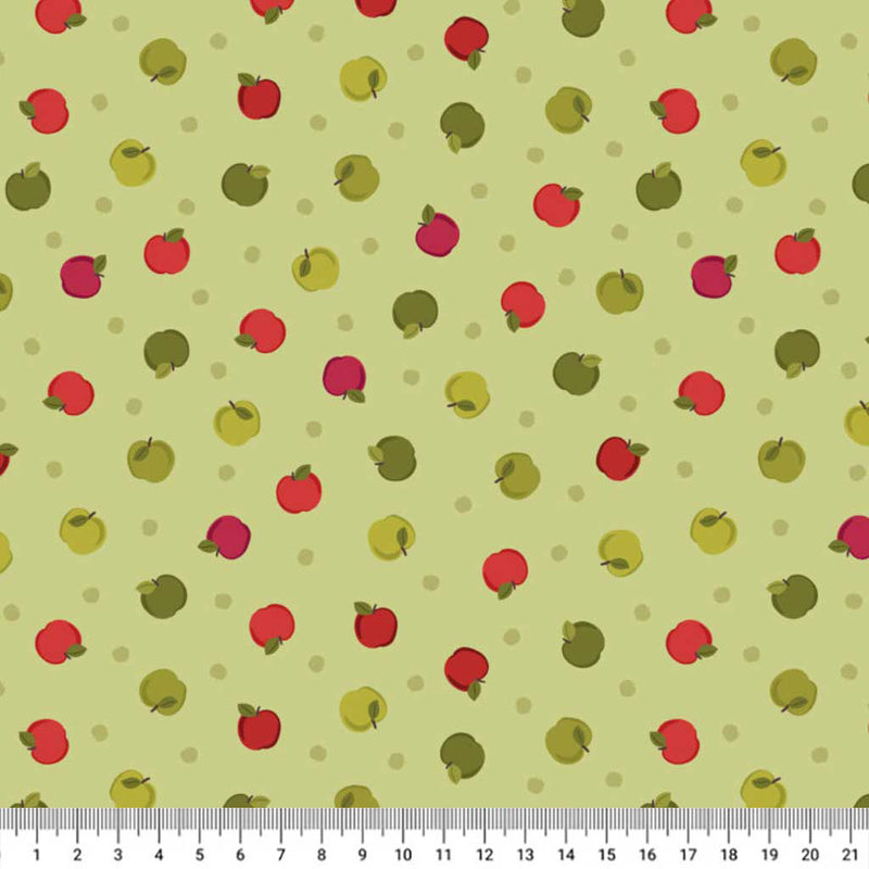 Pattern of red and green apples on a light green cotton quilting fabric with a ruler at the bottom.