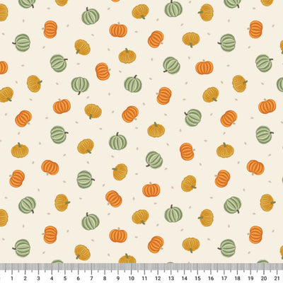 Pattern of pumpkins and gourds on a beige cotton quilting fabric with a ruler at the bottom.