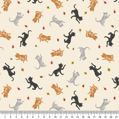 Pattern of coloruful cats on a beige cotton quilting fabric with a ruler at the bottom.