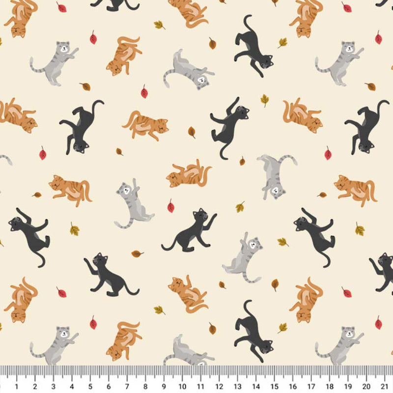 Pattern of coloruful cats on a beige cotton quilting fabric with a ruler at the bottom.