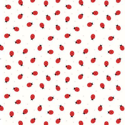 Miniature ladybirds scrambling across a white cotton fabric