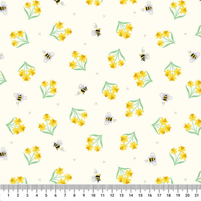 Vibrant mini daffodils surrounded by buzzing bees on a light pastel yellow 100% cotton fabric with a cm ruler.