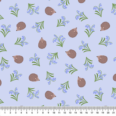 Small hedgehogs scattering along blooming bluebells on a baby blue 100% cotton fabric with a cm ruler