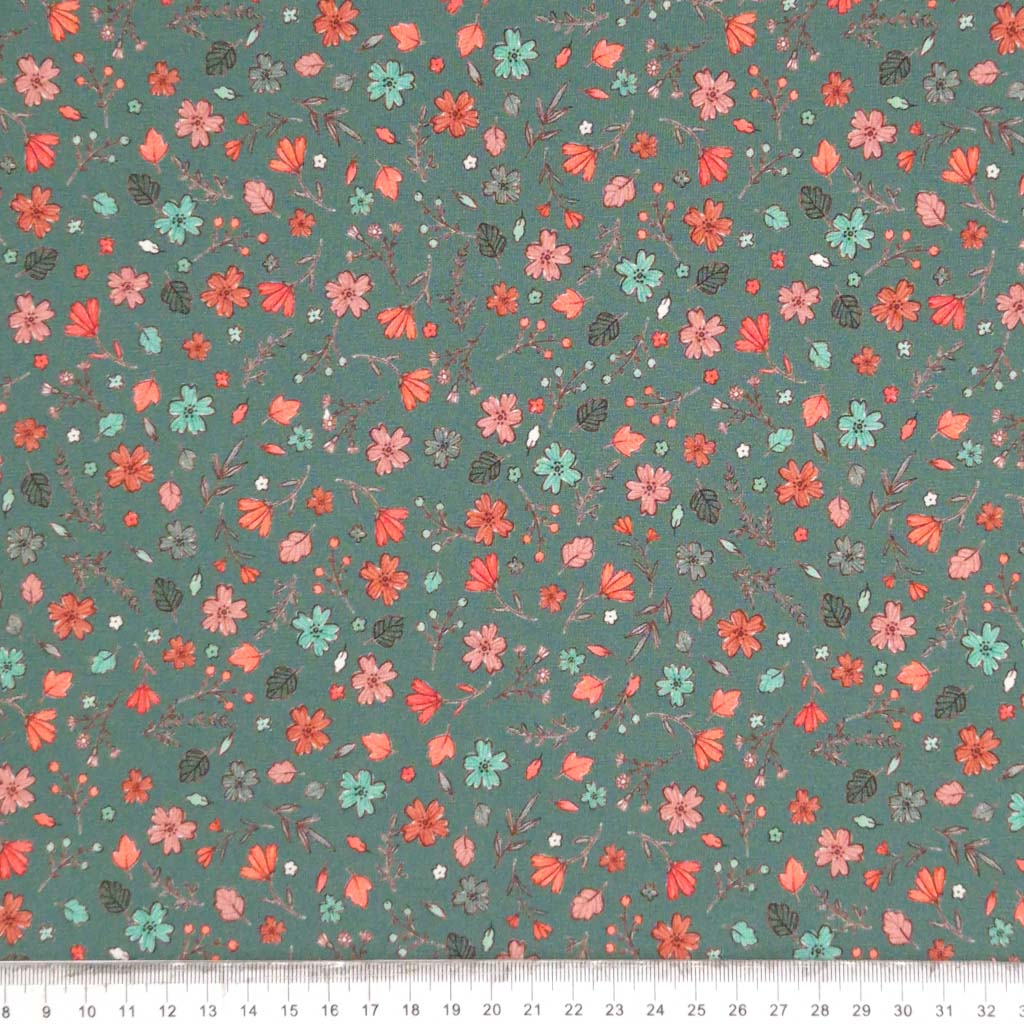 A ditsy floral pattern printed on a duck egg cotton jersey fabric with a cm ruler