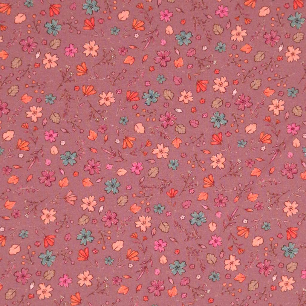 A ditsy floral pattern printed on a dusky pink cotton jersey fabric