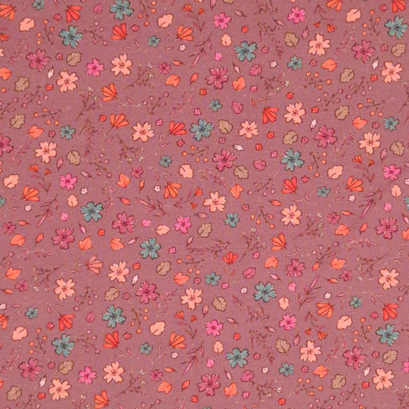 A ditsy floral pattern printed on a dusky pink cotton jersey fabric