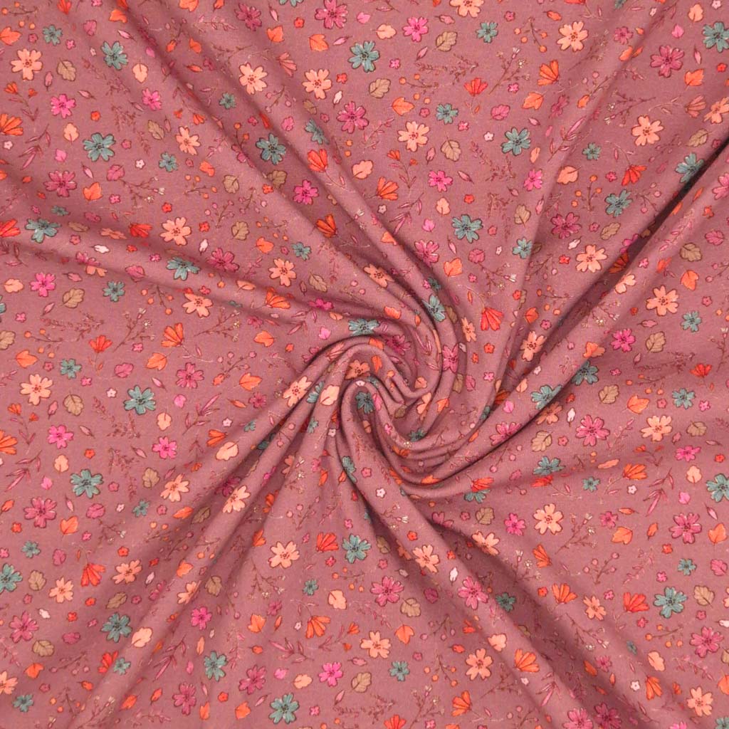 A ditsy floral pattern printed on a dusky pink cotton jersey fabric swirl