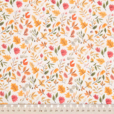 Pattern of autumn leaves and branches on a white polycotton fabric with a cm ruler