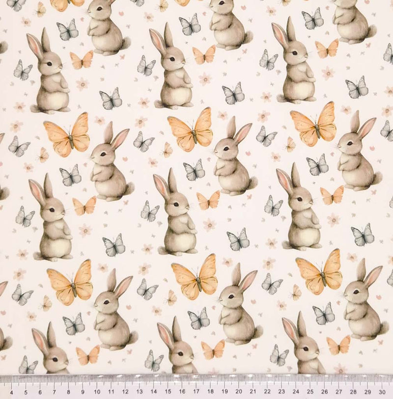 Bunny rabbits and butterflies printed on an ivory cotton poplin fabric with a cm ruler