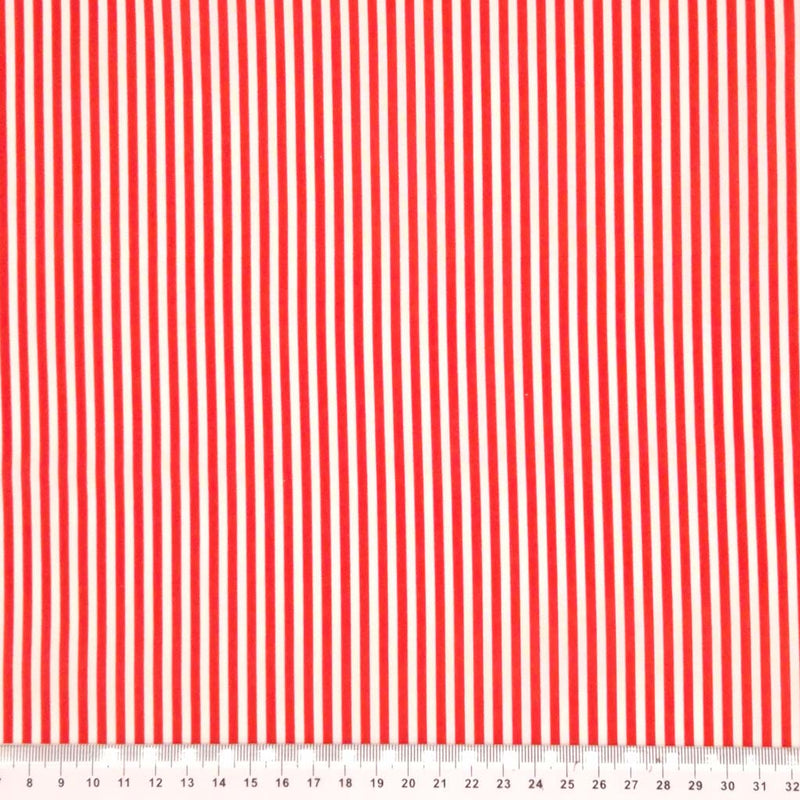 Red candy stripes printed on a white cotton fabric with a cm ruler