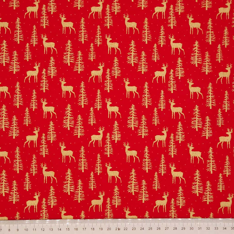 Pattern of deer and trees on a red cotton fabric