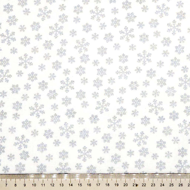 Pattern of snowflakes on a white cotton fabric with a ruler at the bottom.