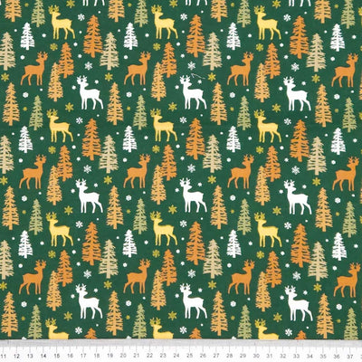 Pattern of deer and trees on a green christmas cotton fabric with measurement scale at the bottom.