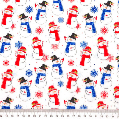 Jolly snowmen printed on a white polycotton fabric with a cm ruler