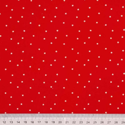 Mini white scattered stars printed on a red 100% cotton fabric with a cm ruler