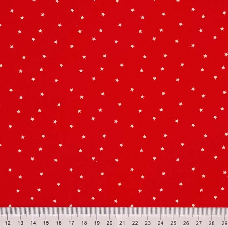 Mini white scattered stars printed on a red 100% cotton fabric with a cm ruler