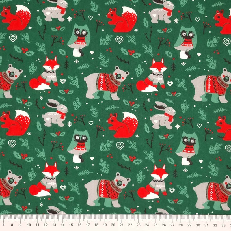 Woodland animals printed on a festive green polycotton fabric with a cm ruler