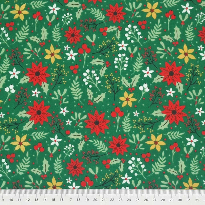 A christmas poinsettia fabric print on a green polycotton with a cm ruler