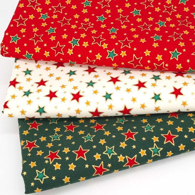 Festive stars with gold lacquer printed on red, ivory and green cotton fabrics in a fat quarter bundle