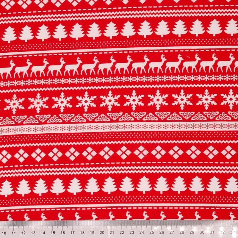 A white scandinavian style design printed on a red christmas polycotton fabric with a cm ruler