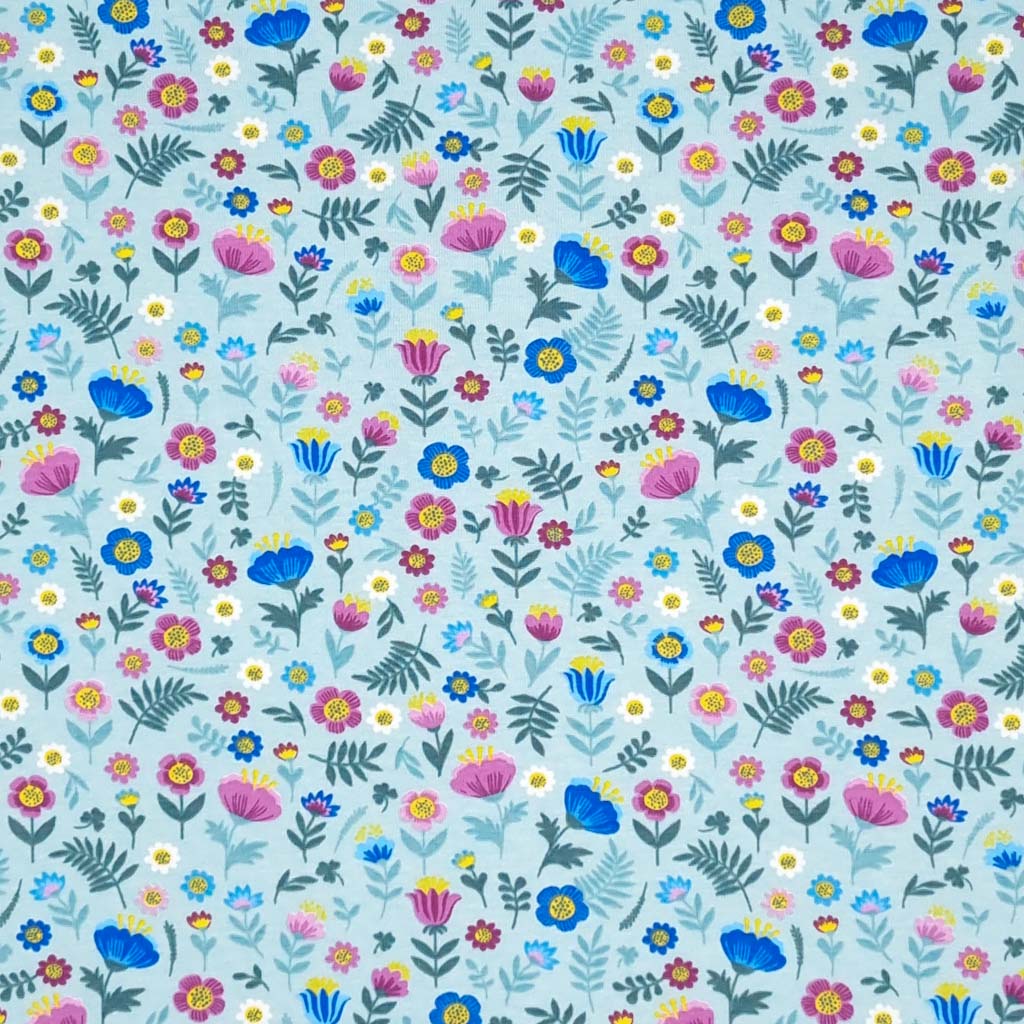 Ditsy flowers are printed on a sky blue cotton jersey fabric