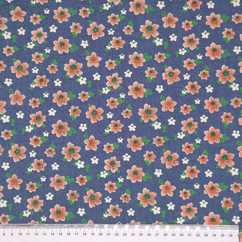 Peach coloured flowers printed on a medium blue cotton denim chambray fabric with a cm ruler