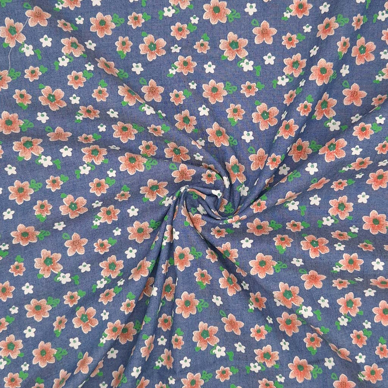 Peach coloured flowers printed on a medium blue cotton denim chambray fabric