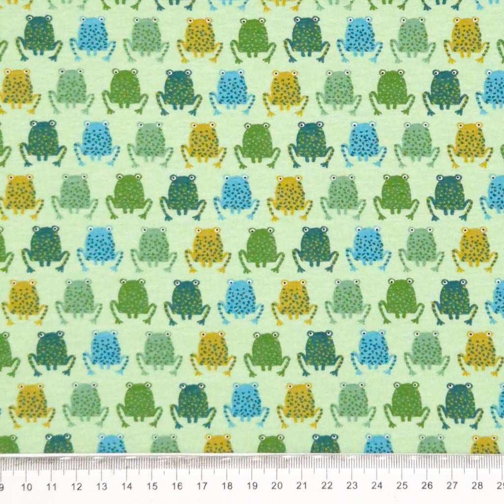 Blue green and yellow frogs printed on a cotton jersey fabric with a cm ruler