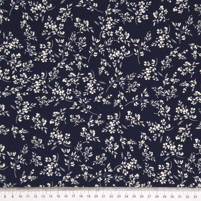 An ivory vine floral printed on a navy cotton poplin fabric by Rose & Hubble with a cm ruler