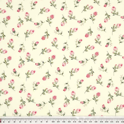 A ditsy pink flower printed on a cream cotton poplin fabric by Rose & Hubble with a cm ruler